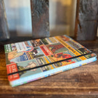 National Parks Vintage Notebook Large shown from a different angle with a vibrant collage cover on a wooden surface