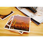 Coaster with Arizona desert scene of cacti and distant hills in warm orange tones and ARIZONA across