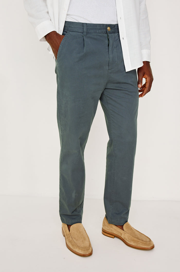 Marcellus Pants with Belt Loops, Two Seam Front Pockets, a Front Buttoned Flap Pocket, a Back Buttoned Welt Pocket and a Back Welt Pocket in Faded Blue Colorway - Front View Featured on Model