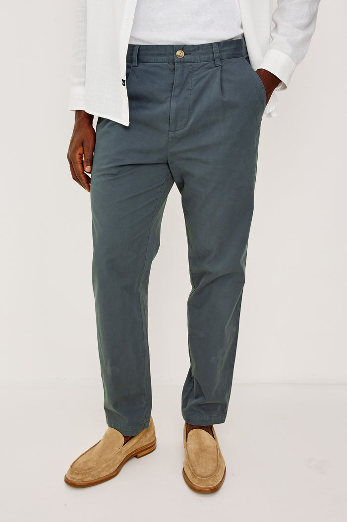 Marcellus Pants with Belt Loops, Two Seam Front Pockets, a Front Buttoned Flap Pocket, a Back Buttoned Welt Pocket and a Back Welt Pocket in Faded Blue Colorway - Front View Featured on Model