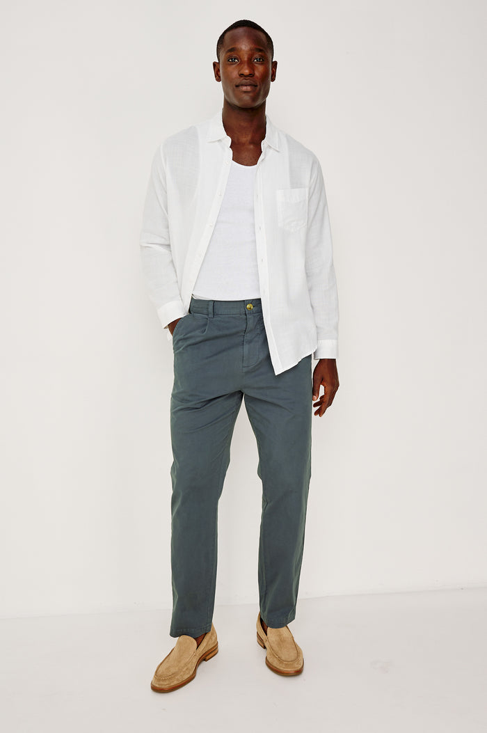 Marcellus Pants with Belt Loops, Two Seam Front Pockets, a Front Buttoned Flap Pocket, a Back Buttoned Welt Pocket and a Back Welt Pocket in Faded Blue Colorway - Front Full Body View Featured on Model