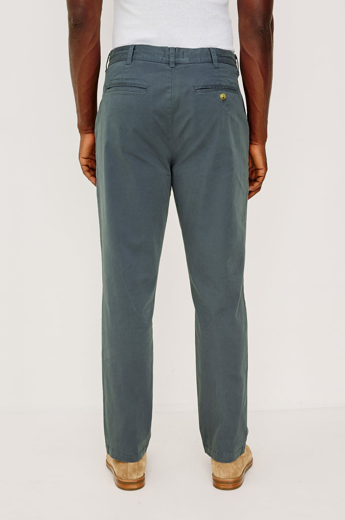 Marcellus Pants with Belt Loops, Two Seam Front Pockets, a Front Buttoned Flap Pocket, a Back Buttoned Welt Pocket and a Back Welt Pocket in Faded Blue Colorway - Back View Featured on Model