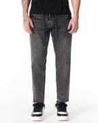 Martin Valen men's faded black jeans, front mid-shot showing straight leg and raw frayed hem