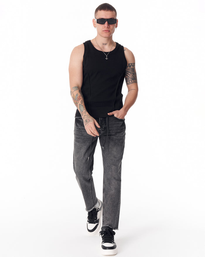 Martin Valen men's faded black straight-leg jeans, front mid-body view showing raw hem and visible drawcord