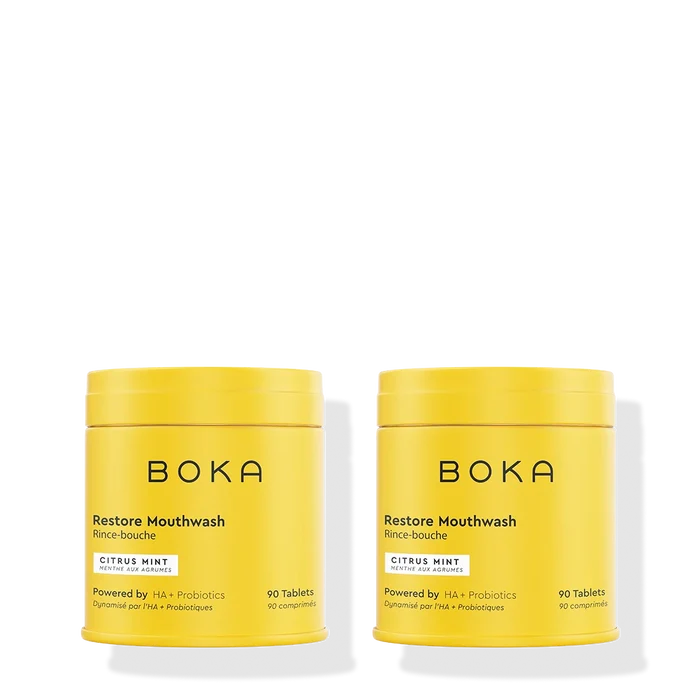 Two yellow containers of Boka Restore Mouthwash on a white background