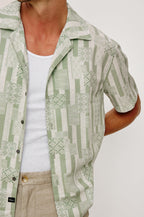 Rhodes Boxy Button-Up Shirt in Crepe With Back Box Pleat, Vintage-Inspired Notched Collar, Front Buttons, and Short Sleeves in Patchwork Stripe Sage Colorway - Upper Body Close Up Front View Featured on Model