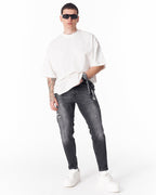 Martin Valen washed black slim-fit jeans with ripped detail, front view on model with bandana at belt loop