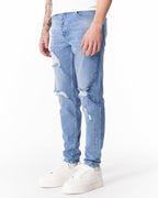 Martin Valen ripped slim-fit jeans in washed blue, side view showing thigh rip and pocket area